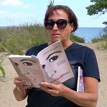 video still of Janet Kuypers reading from her book “(pheromemes) 2015-2017 poems” live