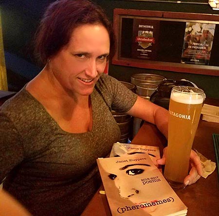 photo of Janet Kuypers with her book “(pheromemes) 2015-2017 poems” at Patagonia Brewingin Buenos Aures