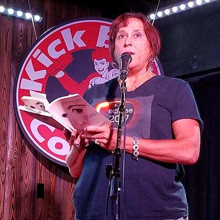 photo of Janet Kuypers reading from her book “(pheromemes) 2015-2017 poems” live