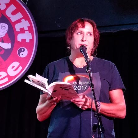 photo of Janet Kuypers reading from her book “(pheromemes) 2015-2017 poems” live