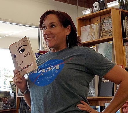 photo of Janet Kuypers, with her book “(pheromemes) 2015-2017 poems” live