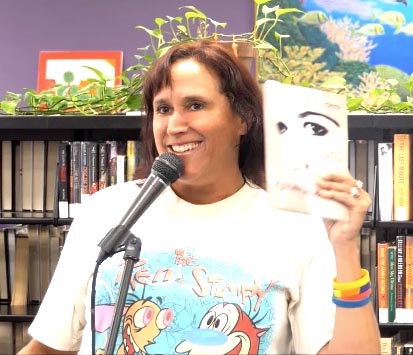 video still of Janet Kuypers reading from her book “(pheromemes) 2015-2017 poems” live