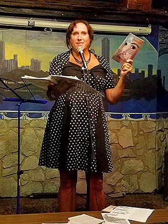 Janet Kuypers with her book “(pheromemes) 2015-2017 show poems” live