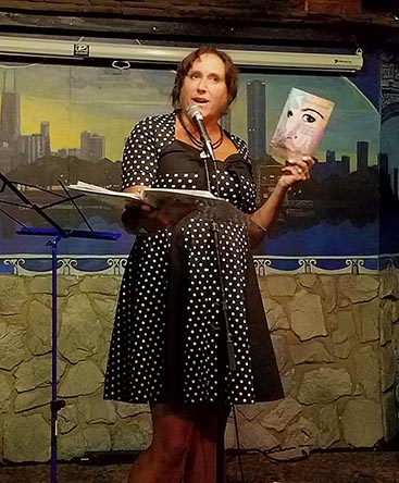 Janet Kuypers with her book “(pheromemes) 2015-2017 show poems” live