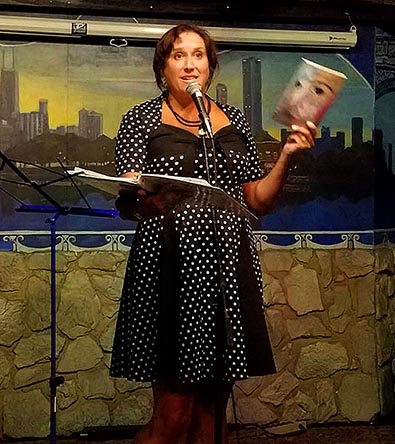 Janet Kuypers with her book “(pheromemes) 2015-2017 show poems” live